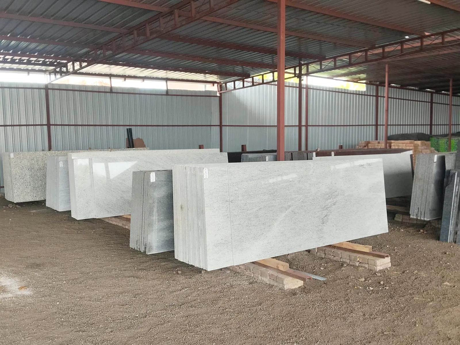 Full-length natural granite slab displayed upright at the Paras Home Decor granite yard